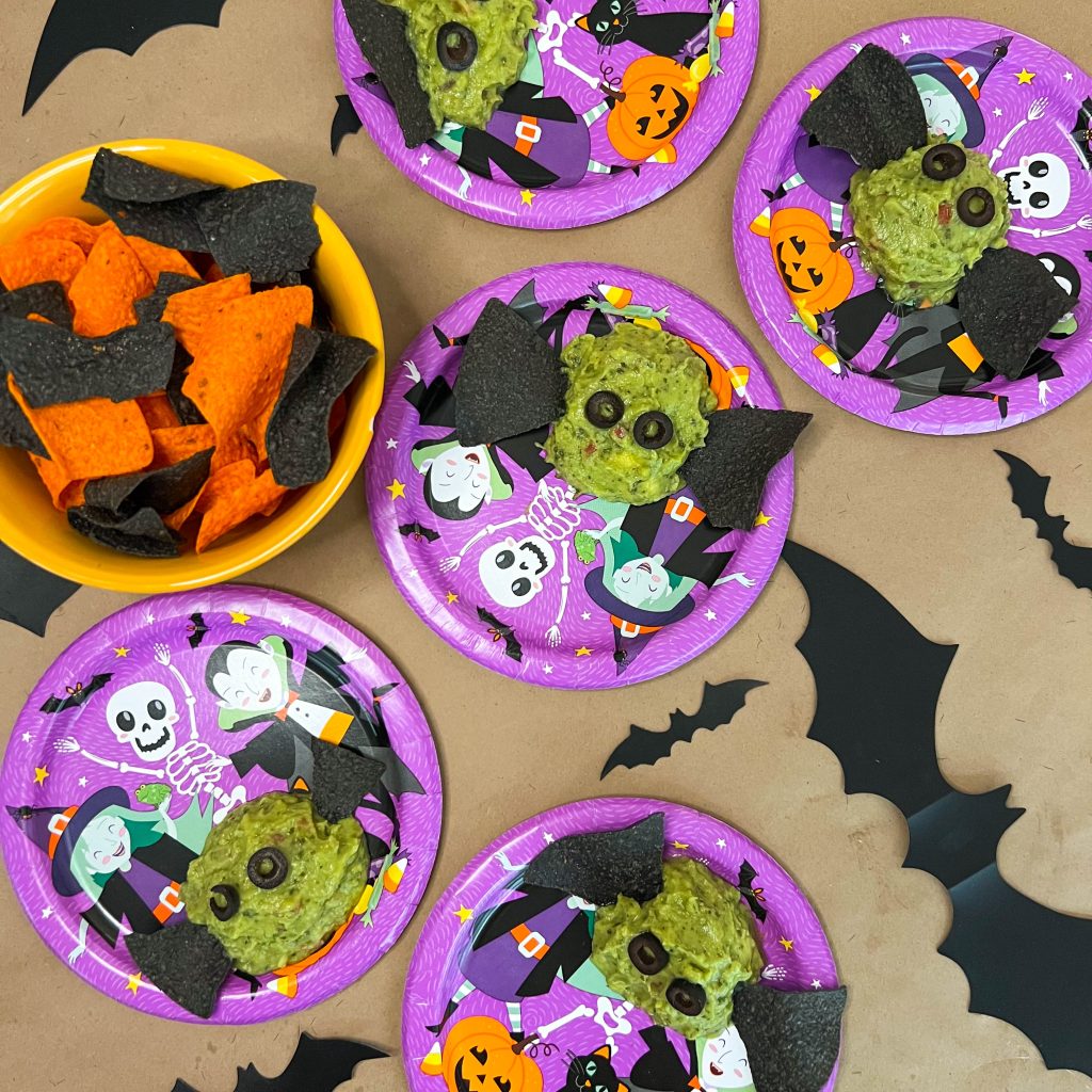 a group of halloween plates with spooky snacks on them